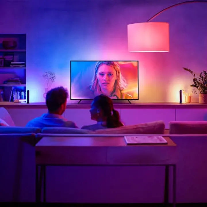 A lounge room lit in blue and pink by smart lighting